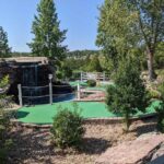 Scenic outdoor miniature golf course area with a waterfall, green putting surface, and landscaped surroundings at Brookside Miniature Golf in Branson, Missouri