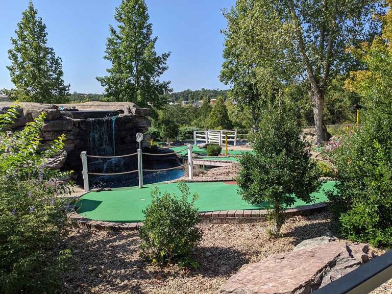 Scenic outdoor miniature golf course area with a waterfall, green putting surface, and landscaped surroundings at Brookside Miniature Golf in Branson, Missouri